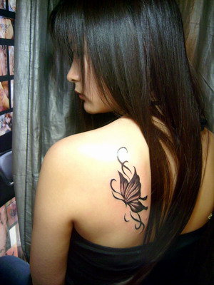The tribal totem style tattoo makes the flowers and butterfly look more 