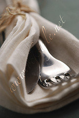 Cutlery in a linen napkin on bottle-green