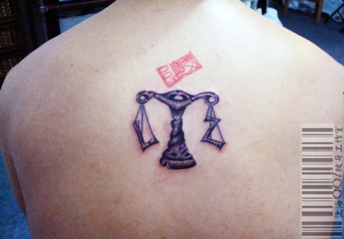 a Libra tattoo design variation on the back with girlfriend's initial on the