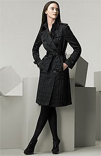 picture of woman standing with legs crossed wearing a black Burberry trench coat