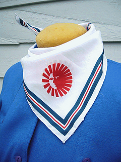 picture of the neck of a mannequin wearing a royal blue shirt with a red and white scarf with a sun in the middle