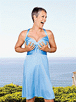 picture of Jamie Lee Curtis in 2008 with silver hair, a blue sundress, grabbing her own breasts