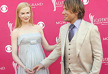 picture of pregnant Nicole Kidman with husband Keith Urban in front of pink background