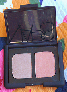 picture of nars eyeshadow compact, open, on a floral background