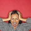 picture of screaming woman with her hands on her head on a red background