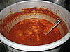The beef chili boils away on the stove. 