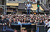 The public gathers outside the area gated off for Yves Saint Laurent's funeral.