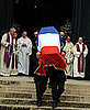 Pallbearers carry Saint Laurent's coffin.