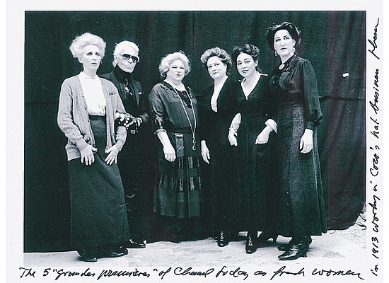 Karl Lagerfeld with Chanel seamstresses costumed as women working in Chanel's hat business in 1913.
