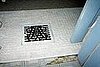 This is an attempt at making a rug look like carpeting. The brass piece on the register looks like a trivet.