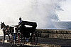A horse and carriage navigates along the Malecon seafront 